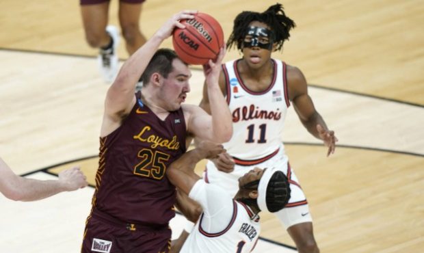 Loyola of Chicago's Cameron Krutwig (25) grabs a rebound above Illinois' Trent Frazier (1) during t...