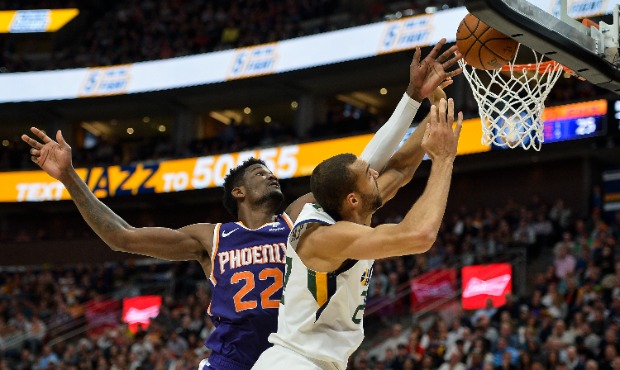 Rudy Gobert #27 of the Utah Jazz fights for the ball with Deandre Ayton #22 of the Phoenix Suns dur...