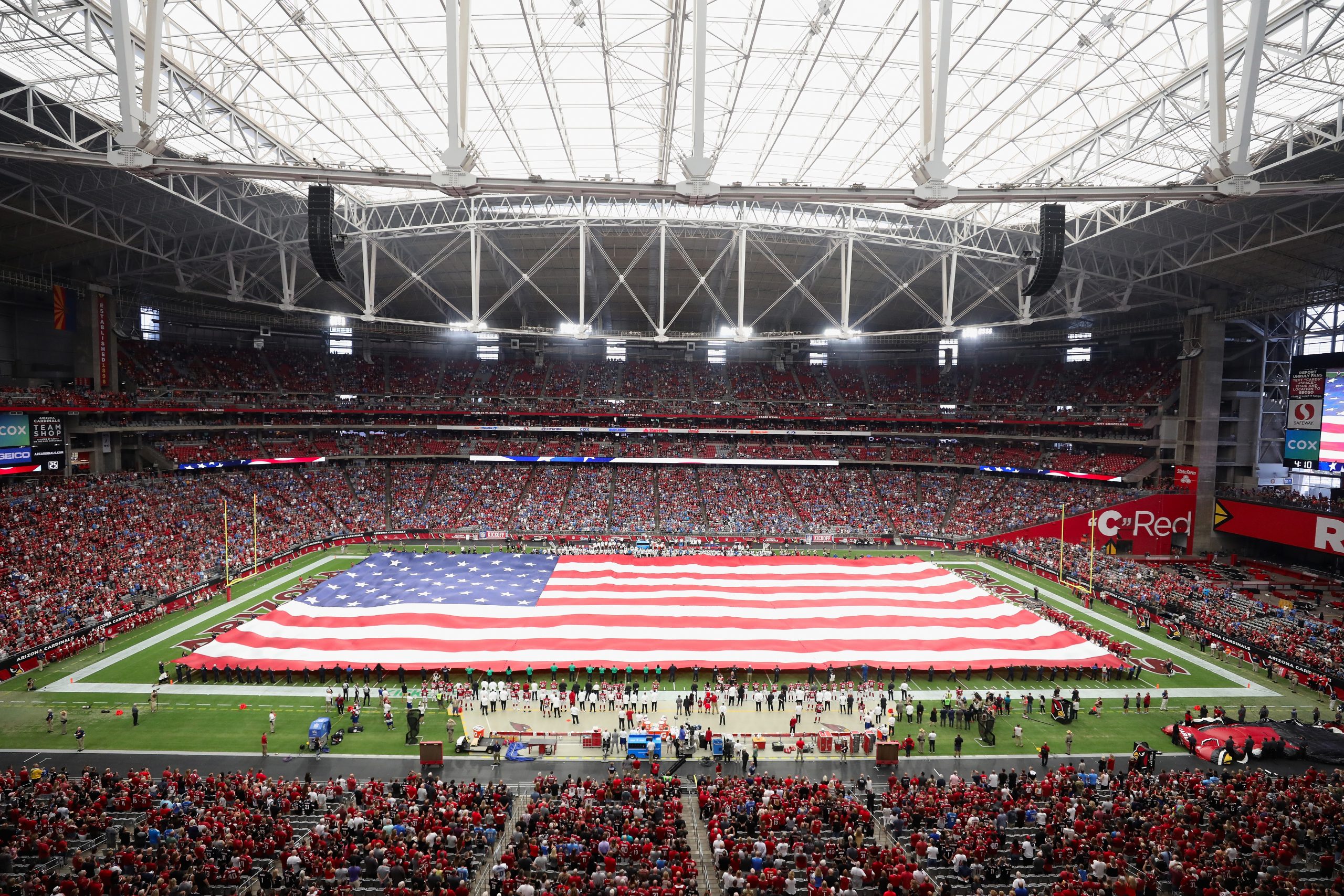 The United States flag is held on the field for the national anthem before the NFL game between the...
