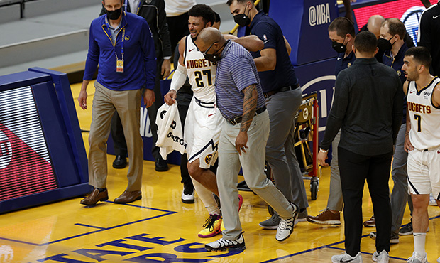 Jamal Murray #27 of the Denver Nuggets is helped off the court after an injury in their game agains...