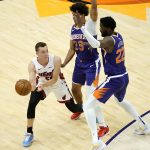 Miami Heat guard Duncan Robinson (55) looks to pass as Phoenix Suns center Deandre Ayton, right, and forward Cameron Johnson (23) defend during the second half of an NBA basketball game, Tuesday, April 13, 2021, in Phoenix. (AP Photo/Matt York)
