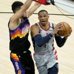 Washington Wizards guard Russell Westbrook (4) drives as Phoenix Suns guard Devin Booker (1) defends during the second half of an NBA basketball game, Saturday, April 10, 2021, in Phoenix. (AP Photo/Matt York)