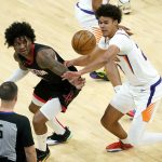 Houston Rockets guard Kevin Porter Jr. and Phoenix Suns forward Cameron Johnson, right, battle for a loose ball during the first half of an NBA basketball game, Monday, April 12, 2021, in Phoenix. (AP Photo/Matt York)