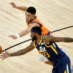 Phoenix Suns guard Devin Booker and Utah Jazz forward Royce O'Neale (23) battle for the ball during the first half of an NBA basketball game, Friday, April 30, 2021, in Phoenix. (AP Photo/Matt York)