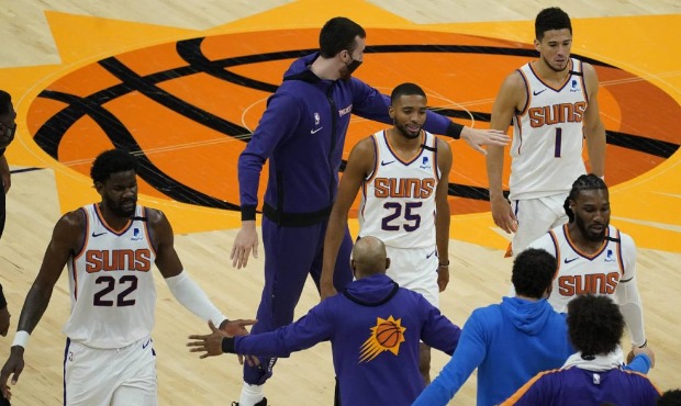 The Phoenix Suns celebrate during a time out during the second half of an NBA basketball game again...