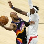 
              Phoenix Suns guard Jevon Carter shoots as Los Angeles Clippers guard Reggie Jackson, right, defends during the first half of an NBA basketball game, Wednesday, April 28, 2021, in Phoenix. (AP Photo/Matt York)
            