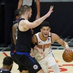 Phoenix Suns guard Devin Booker, right, tries to dribble around Los Angeles Clippers center Ivica Zubac during the first half of an NBA basketball game Thursday, April 8, 2021, in Los Angeles. (AP Photo/Marcio Jose Sanchez)