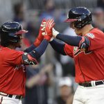 Atlanta Braves' Austin Riley, right, is congratulated by Ozzie Albies after hitting a two-run home run off Arizona Diamondbacks pitcher Luke Weaver in the second inning of a baseball game Friday, April 23, 2021, in Atlanta. (AP Photo/Ben Margot)