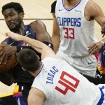 Phoenix Suns center Deandre Ayton rebounds over Los Angeles Clippers center Ivica Zubac (40) during the first half of an NBA basketball game, Wednesday, April 28, 2021, in Phoenix. (AP Photo/Matt York)