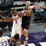 Phoenix Suns guard Chris Paul (3) and Houston Rockets forward D.J. Wilson (00) battle for the ball during the first half of an NBA basketball game, Monday, April 12, 2021, in Phoenix. (AP Photo/Matt York)