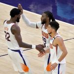 Phoenix Suns forward Jae Crowder (99) celebrates with guard Devin Booker and center Deandre Ayton (22) during the first half of an NBA basketball game against the Houston Rockets, Monday, April 12, 2021, in Phoenix. (AP Photo/Matt York)