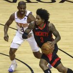 Houston Rockets guard Kevin Porter Jr., right, dribbles the ball against Phoenix Suns guard Chris Paul, left, during the first quarter of an NBA basketball game in Houston, Monday, April 5, 2021. (Troy Taormina/Pool Photo via AP)