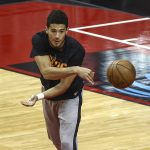 Suns guard Devin Booker (1) warms up before an NBA basketball game against the Houston Rockets in Houston, Monday, April 5, 2021. (Troy Taormina/Pool Photo via AP)