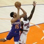 Phoenix Suns guard Cameron Payne (15) shoots over Miami Heat guard Kendrick Nunn (25) during the first half of an NBA basketball game, Tuesday, April 13, 2021, in Phoenix. (AP Photo/Matt York)
