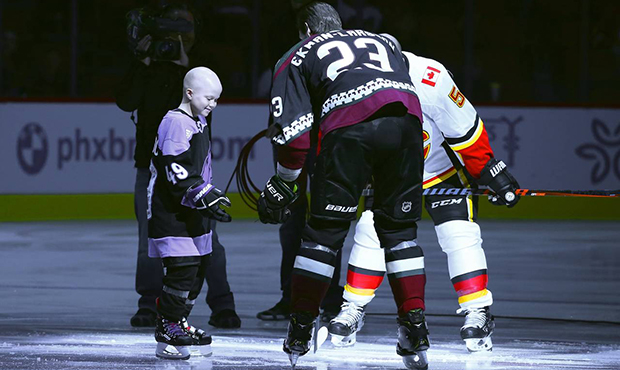 Leighton Accardo, left, who is battling cancer, drops the puck in front of Arizona Coyotes' Oliver ...