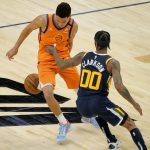 Utah Jazz guard Jordan Clarkson (00) steals the ball from Phoenix Suns guard Devin Booker (1) during the second half of an NBA basketball game, Friday, April 30, 2021, in Phoenix. (AP Photo/Matt York)