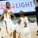 Phoenix Suns' Mikal Bridges, left, is congratulated by Chris Paul, right, during overtime of an NBA basketball game against the Milwaukee Bucks Monday, April 19, 2021, in Milwaukee. (AP Photo/Aaron Gash)