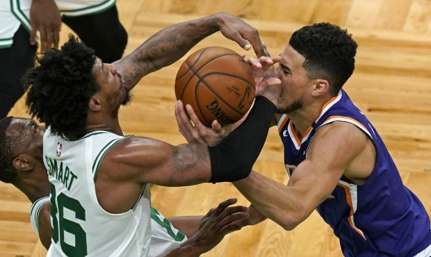 Boston Celtics guard Marcus Smart (36) and Phoenix Suns guard Devin Booker (1) compete for the ball...