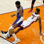 Miami Heat forward Trevor Ariza (8) fouls Phoenix Suns center Deandre Ayton during the first half of an NBA basketball game, Tuesday, April 13, 2021, in Phoenix. (AP Photo/Matt York)