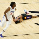 Phoenix Suns guard Devin Booker lies on the court after losing the ball as Los Angeles Clippers guard Terance Mann (14) runs up court during the second half of an NBA basketball game, Wednesday, April 28, 2021, in Phoenix. (AP Photo/Matt York)