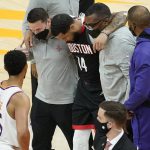 Houston Rockets guard D.J. Augustin (14) is helped off the court after an injury against the Phoenix Suns during the first half of an NBA basketball game, Monday, April 12, 2021, in Phoenix. (AP Photo/Matt York)