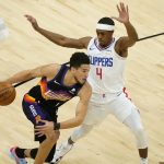 Phoenix Suns guard Devin Booker (1) drives as Los Angeles Clippers guard Rajon Rondo (4) defends during the first half of an NBA basketball game, Wednesday, April 28, 2021, in Phoenix. (AP Photo/Matt York)