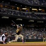 San Diego Padres' Fernando Tatis Jr. follows through on a double during the sixth inning of a baseball game against the Arizona Diamondbacks, Tuesday, April 27, 2021, in Phoenix. (AP Photo/Matt York)