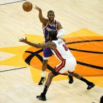 Phoenix Suns guard Chris Paul passes over Miami Heat forward Trevor Ariza (8) during the first half of an NBA basketball game, Tuesday, April 13, 2021, in Phoenix. (AP Photo/Matt York)