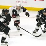 Los Angeles Kings left wing Andreas Athanasiou, left, and defenseman Kale Clague, right, go after the puck along with Arizona Coyotes defenseman Jakob Chychrun during the first period of an NHL hockey game Monday, April 5, 2021, in Los Angeles. (AP Photo/Mark J. Terrill)