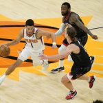 Phoenix Suns guard Devin Booker (1) drives as Houston Rockets forward Kelly Olynyk (41) and guard Armoni Brooks defend during the first half of an NBA basketball game, Monday, April 12, 2021, in Phoenix. (AP Photo/Matt York)