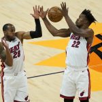Miami Heat forward Jimmy Butler (22) and forward Andre Iguodala (28) reach for the rebound during the first half of an NBA basketball game against the Phoenix Suns, Tuesday, April 13, 2021, in Phoenix. (AP Photo/Matt York)