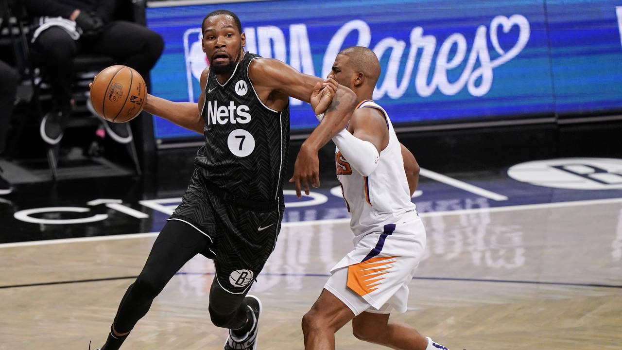 Brooklyn Nets forward Kevin Durant (7) becomes entangled with Phoenix Suns guard Chris Paul during ...