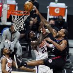Los Angeles Clippers forward Kawhi Leonard, right, dunks over Phoenix Suns center Deandre Ayton (22) during the second half of an NBA basketball game Thursday, April 8, 2021, in Los Angeles. (AP Photo/Marcio Jose Sanchez)