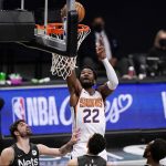 Phoenix Suns center Deandre Ayton (22) dunks with four Brooklyn Nets defenders watching during the first quarter of an NBA basketball game, Sunday, April 25, 2021, in New York. (AP Photo/Kathy Willens)