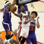 Miami Heat forward Jimmy Butler (22) is fouled by Phoenix Suns forward Torrey Craig, left, as forward Cameron Johnson (23) looks on during the second half of an NBA basketball game, Tuesday, April 13, 2021, in Phoenix. (AP Photo/Matt York)