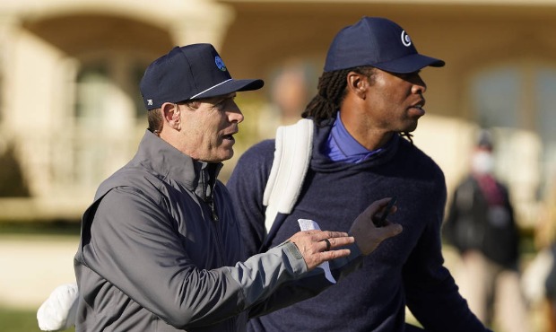 Steve Young, left, looks over the second green with Larry Fitzgerald during the charity challenge e...