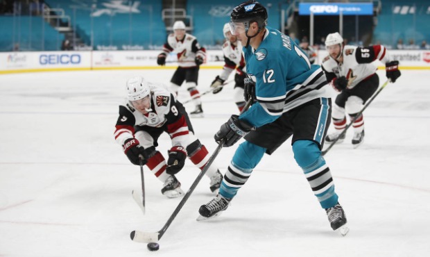 Arizona Coyotes right wing Clayton Keller (9) fights for the puck against the San Jose Sharks cente...