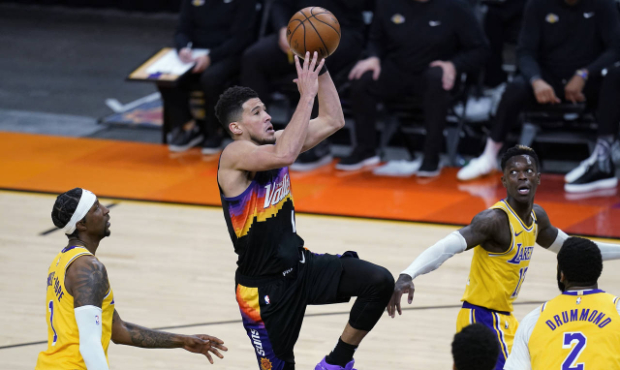 Phoenix Suns guard Devin Booker gets off a shot as Los Angeles Lakers guard Kentavious Caldwell-Pop...