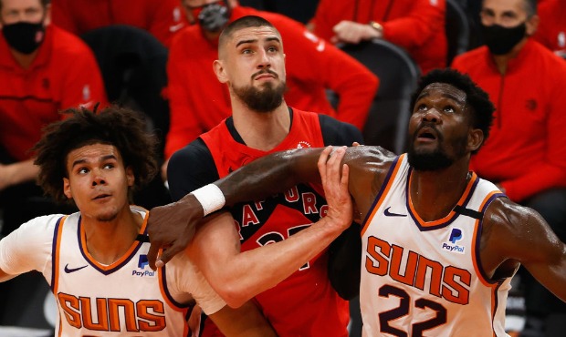 Deandre Ayton #22 and Cameron Johnson #23 of the Phoenix Suns block out Alex Len #27 of the Toronto...