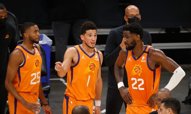 Devin Booker #1 of the Phoenix Suns talks with Deandre Ayton #22 and Mikal Bridges #25 during the N...