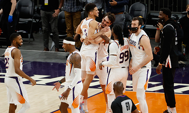 Devin Booker #1 of the Phoenix Suns celebrates with Dario Saric #20 after defeating the Portland Tr...