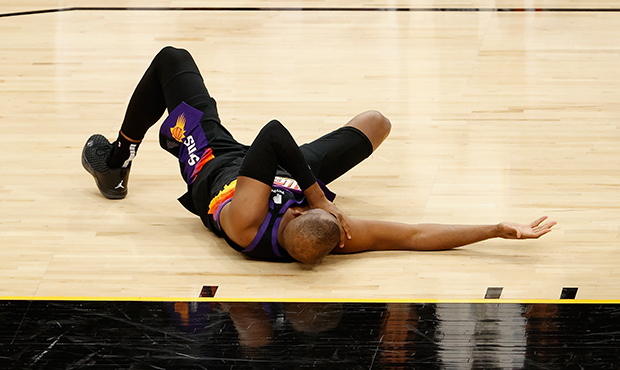 Chris Paul #3 of the Phoenix Suns falls to the floor after an injury during the first half of Game ...