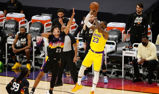 LeBron James #23 of the Los Angeles Lakers attempts a three-point shot over Cameron Johnson #23 of ...