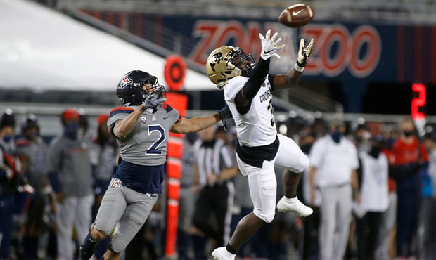 Wide receiver K.D. Nixon #3 of the Colorado Buffaloes leaps to catch a pass as Lorenzo Burns #2 of ...