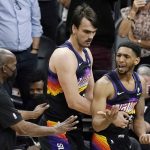 Phoenix Suns guard Cameron Payne, right, is pulled away from an on-court shoving match by teammate Dario Saric, middle, during the second half of Game 1 of their NBA basketball first-round playoff series against the Los Angeles Lakers Sunday, May 23, 2021, in Phoenix. The Suns defeated the Lakers 99-90. (AP Photo/Ross D. Franklin)