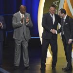 Sean Sutton, right, son of Eddie Sutton, shakes hands with Kansas coach Bill Self, as Kentucky coach John Calipari, left, and Sidney Moncrief after his father was enshrined as part of the 2020 Basketball Hall of Fame class, Saturday, May 15, 2021, in Uncasville, Conn. Moncrief played at Arkansas while Eddie Sutton coached there. (AP Photo/Kathy Willens)