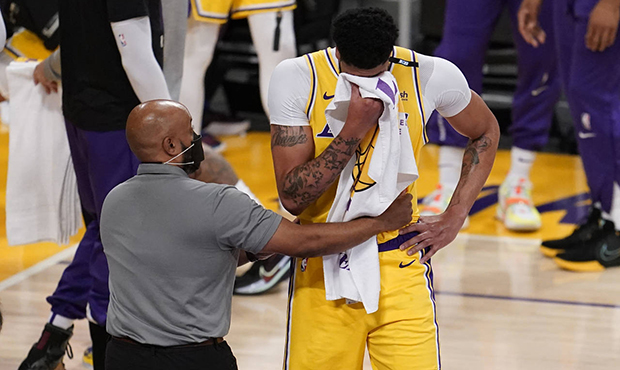 Los Angeles Lakers forward Anthony Davis wipes his face after taking an elbow to the face from Phoe...