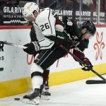 Los Angeles Kings defenseman Sean Walker (26) battles with Arizona Coyotes center Derick Brassard (16) for the puck during the first period of an NHL hockey game Monday, May 3, 2021, in Glendale, Ariz. (AP Photo/Ross D. Franklin)