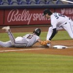 Arizona Diamondbacks' Josh Rojas (10) slides safely back to third as Miami Marlins third baseman Brian Anderson (15) makes a late tag during the fifth inning of a baseball game, Thursday, May 6, 2021, in Miami. Marlins second baseman Jon Berti was charged with an error on the play. (AP Photo/Lynne Sladky)