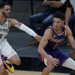 Phoenix Suns guard Devin Booker (1) drives around San Antonio Spurs guard Quinndary Weatherspoon (15) during the first half of an NBA basketball game in San Antonio, Saturday, May 15, 2021. (AP Photo/Eric Gay)